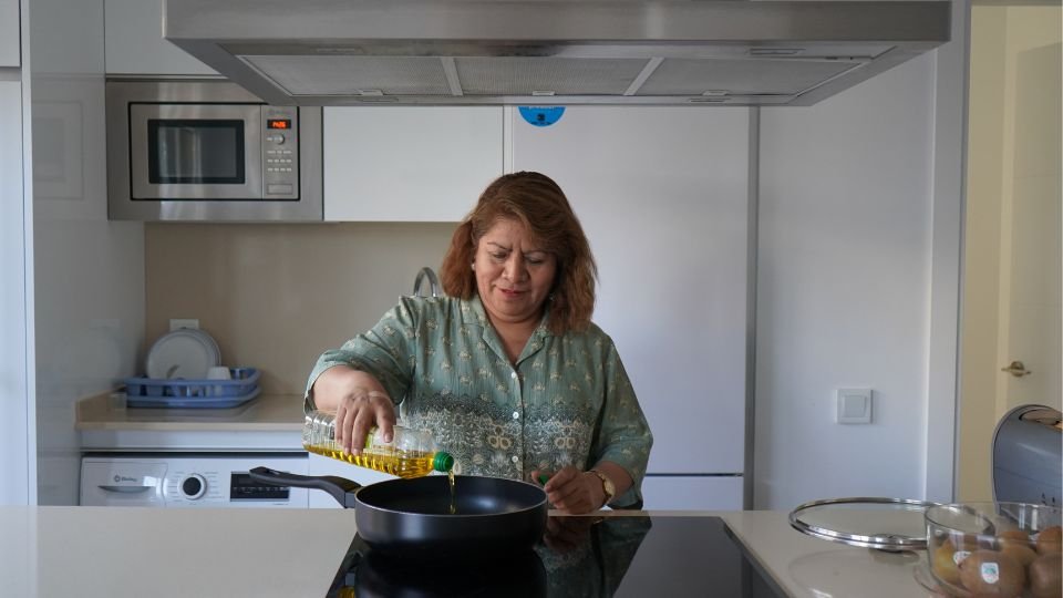 Teresa echando aceite en una sarten