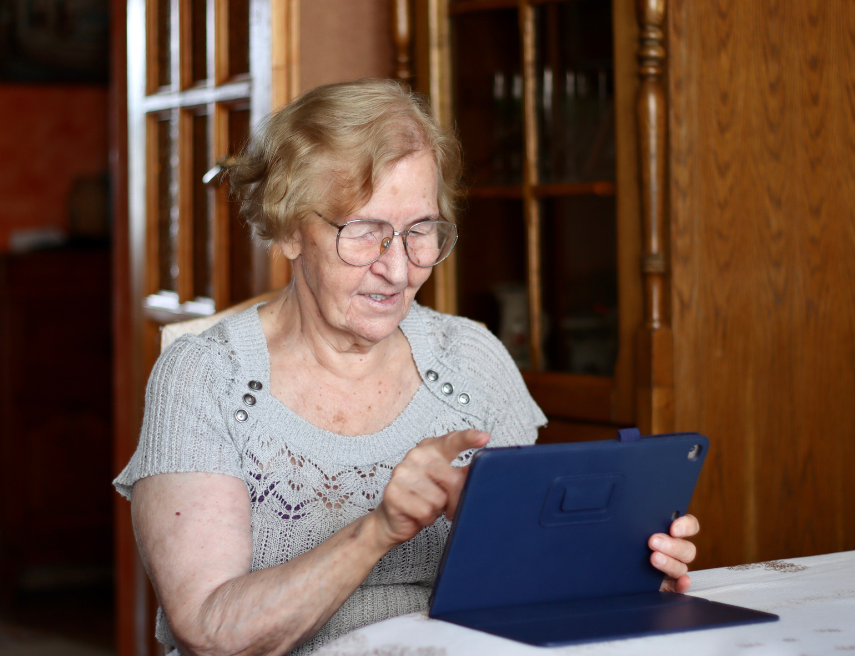 Una persona mayor utiliza la tablet en su casa.